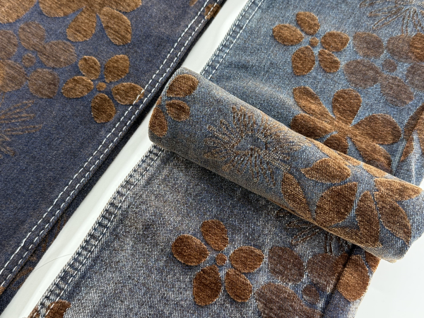 Closeup of floral textured denim fabric with chenille jacquard flower pattern