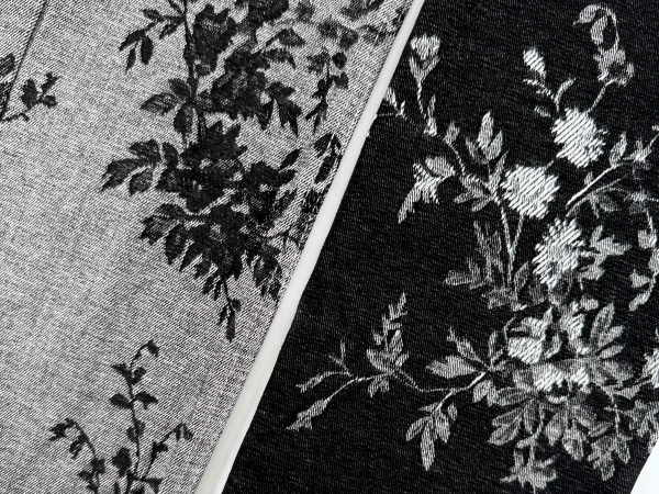 Close-up texture of black floral chenille jacquard denim fabric showing raised floral surface and denim base_